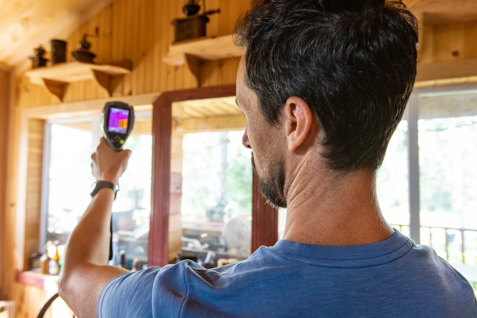 A specialist inspecting a wall with a thermal instrument