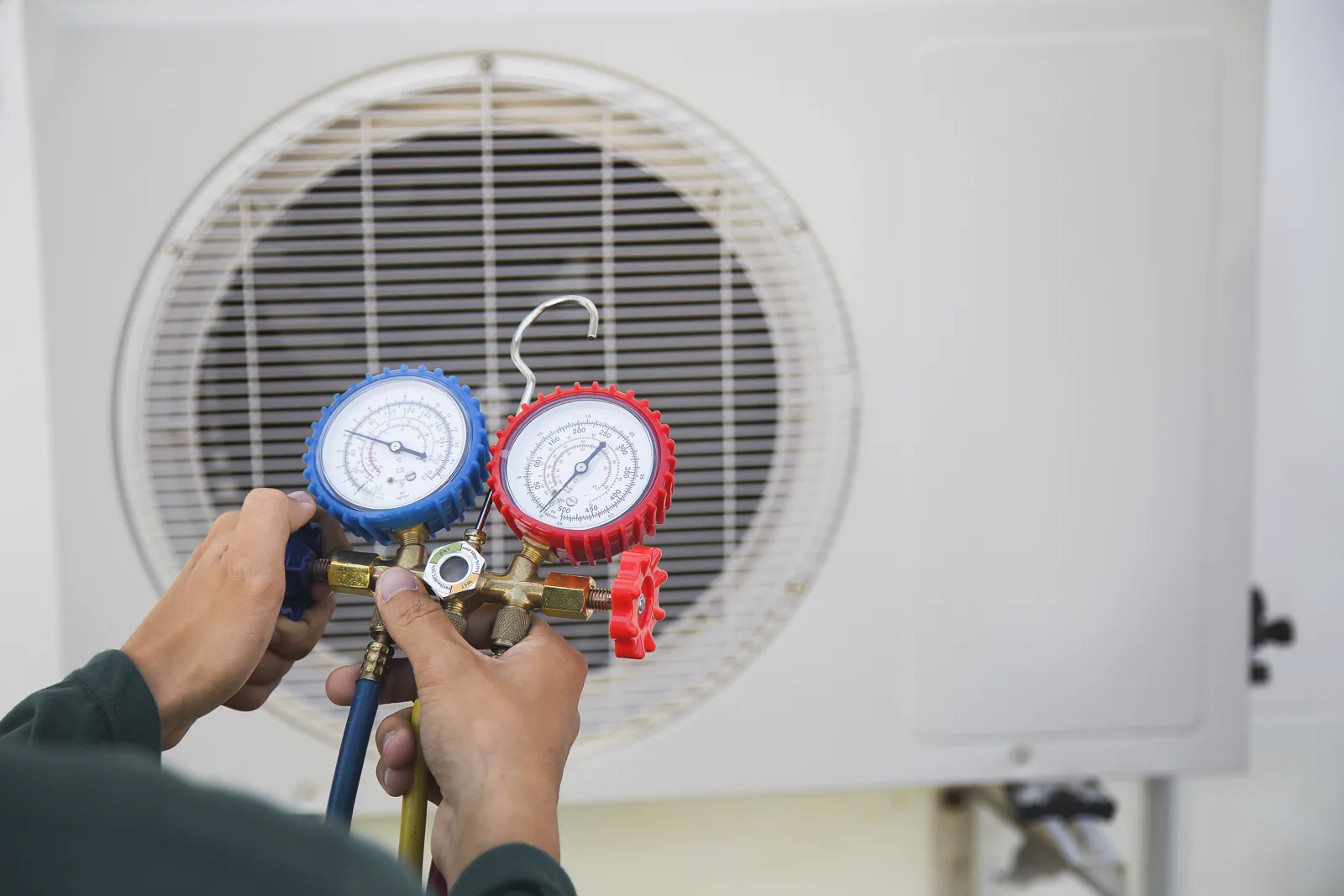 A technician checking an outdoor HVAC unit