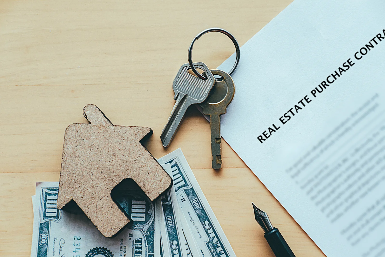 House keys beside a home purchase contract